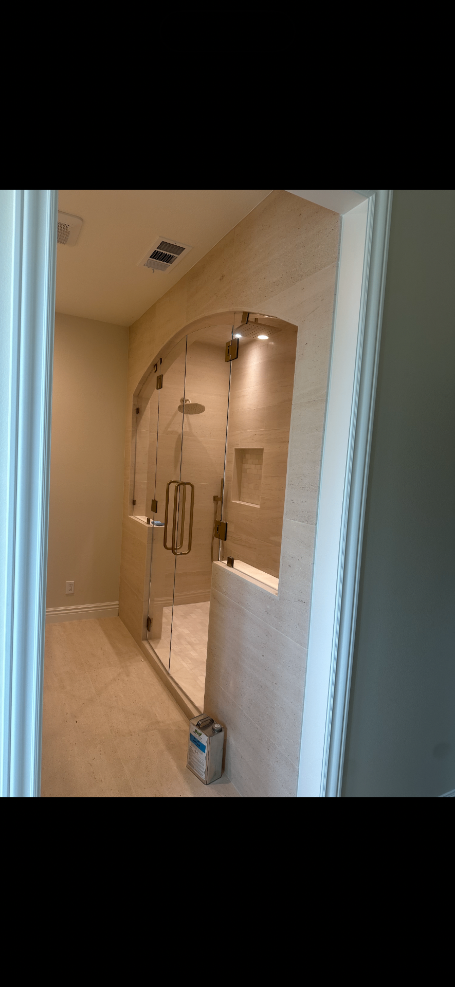 Glass shower door with stone tile surround